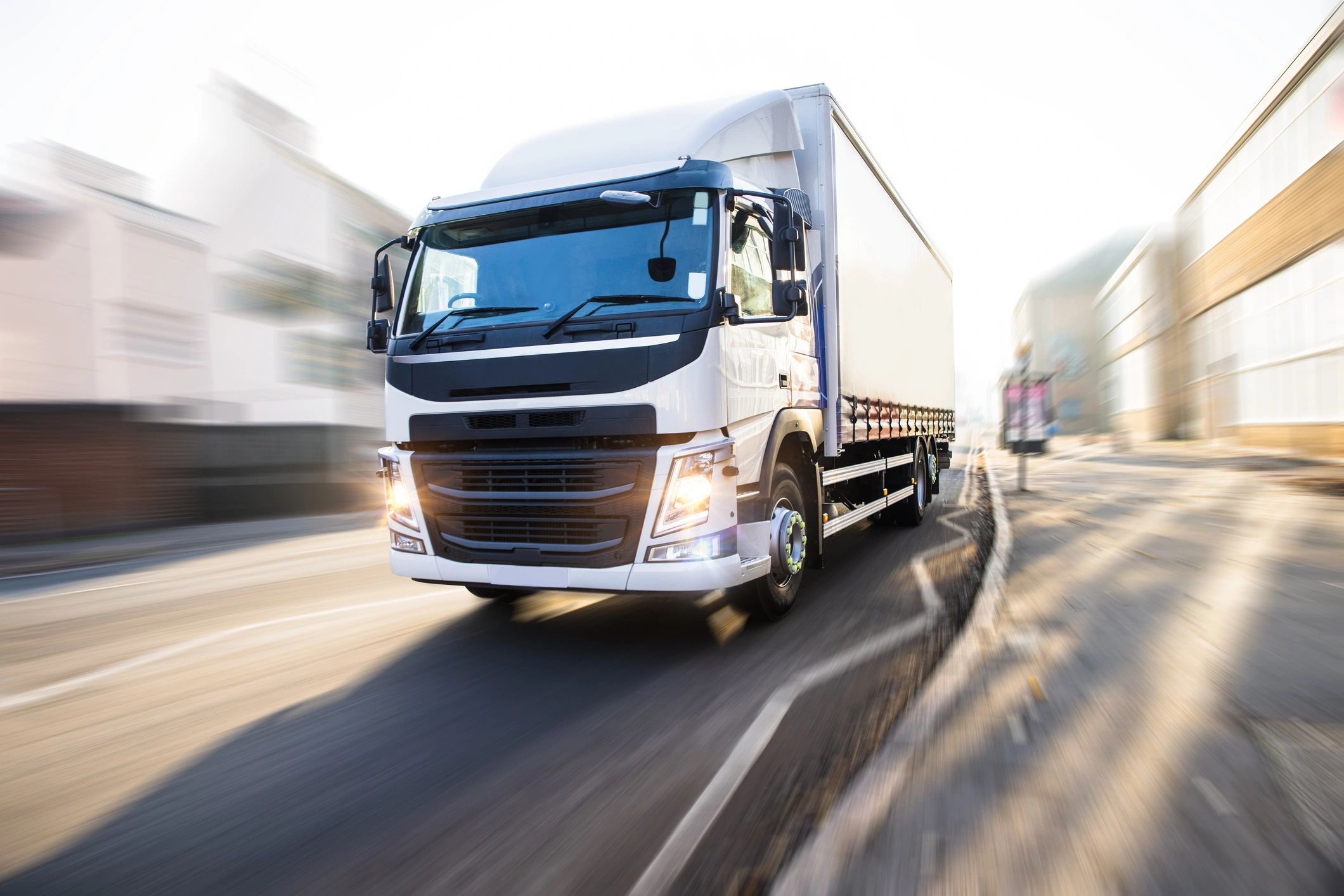A large truck speeds down a highway with motion blur.